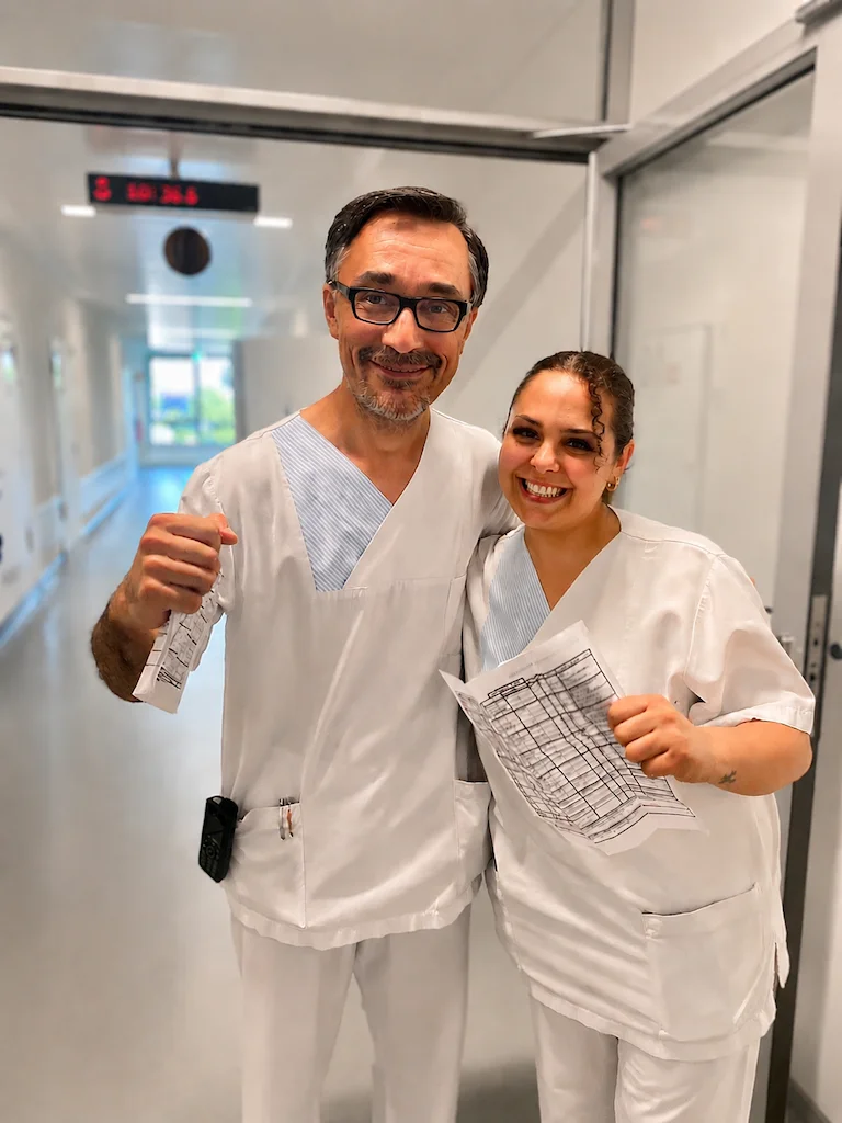 Zwei Pflegekräfte auf dem Gang des Klinikum lachen in die Kamera